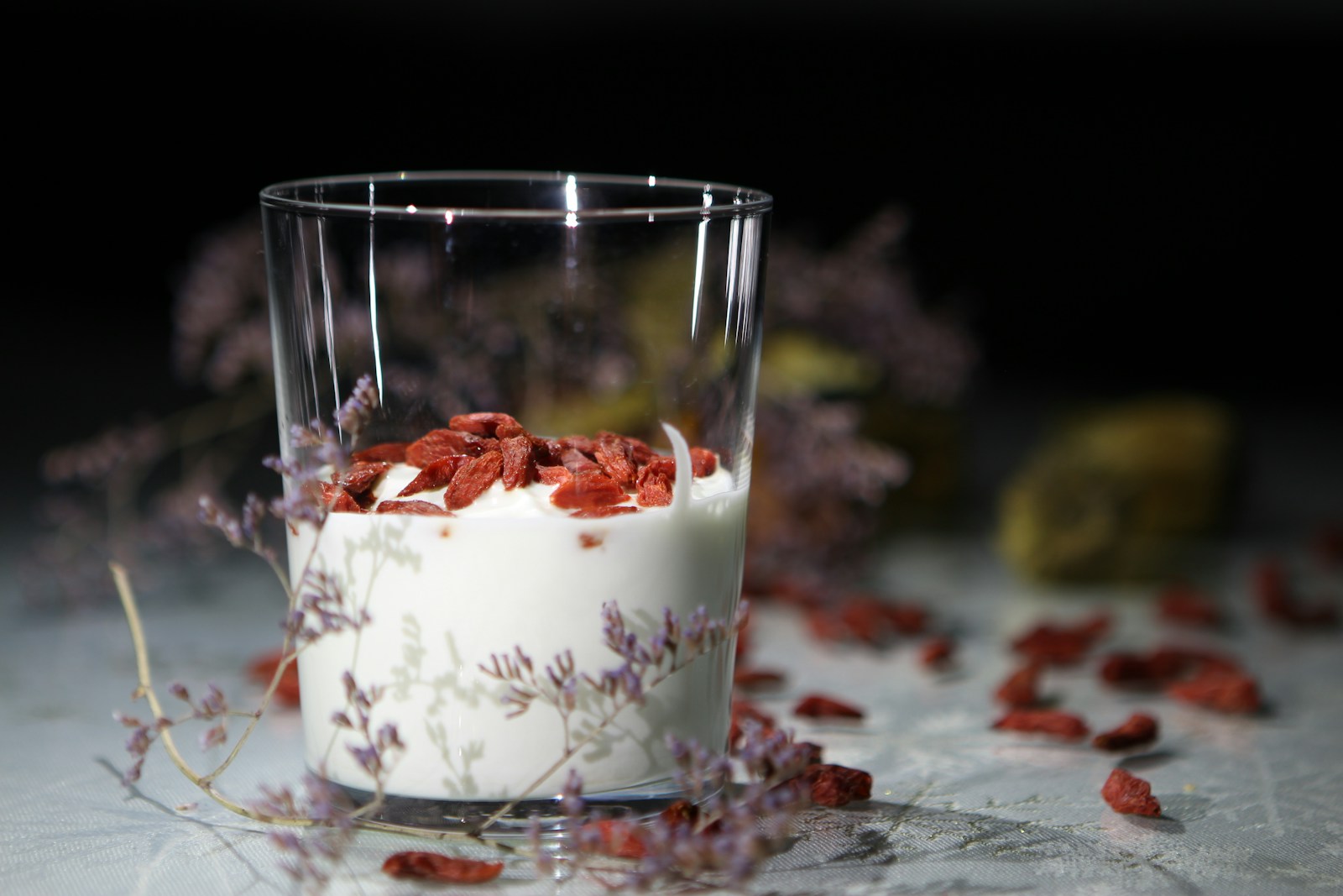A glass of plain yogurt topped with dried goji berries