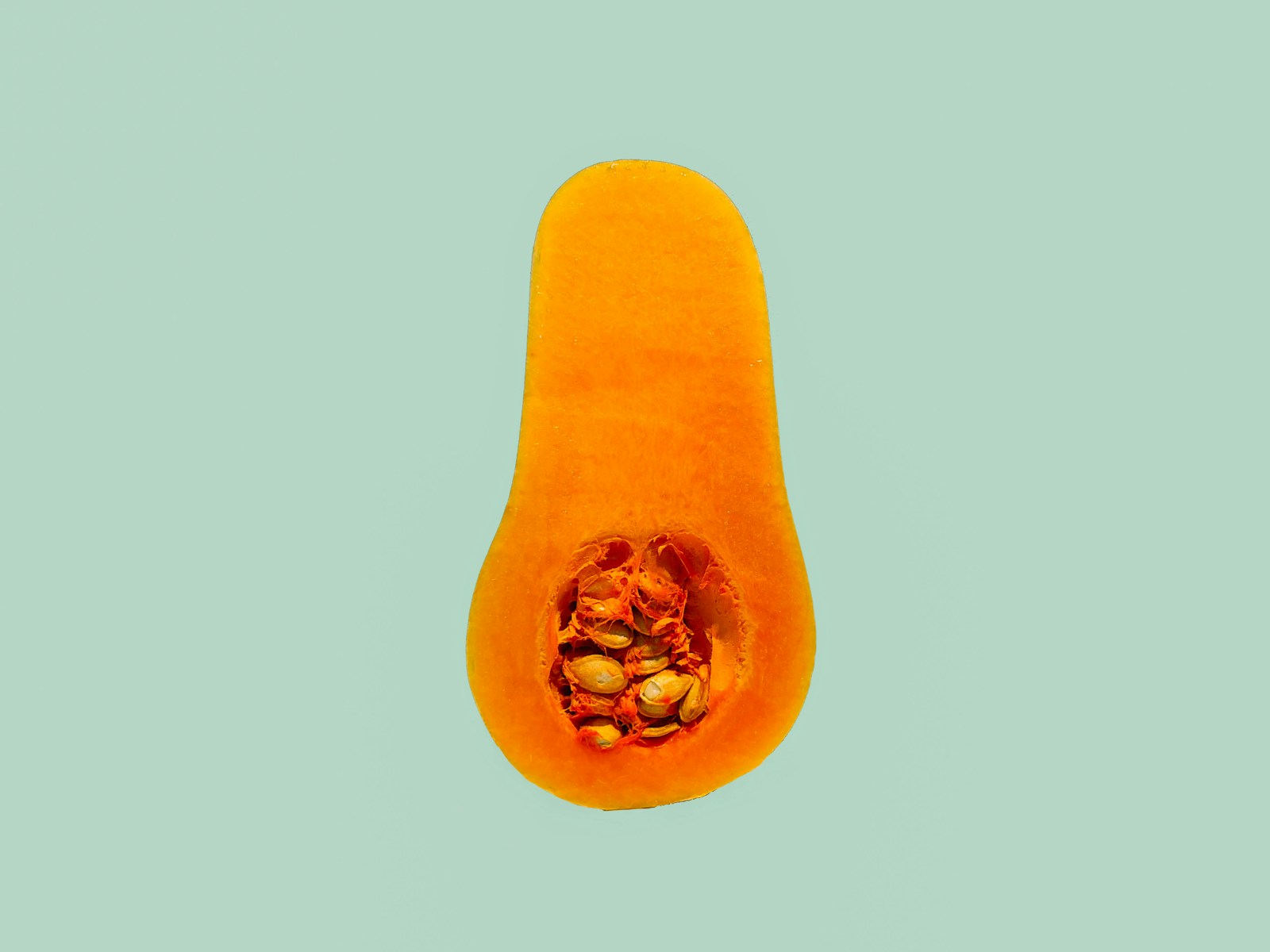 Half a butternut squash showing deep orange flesh and a seed cavity