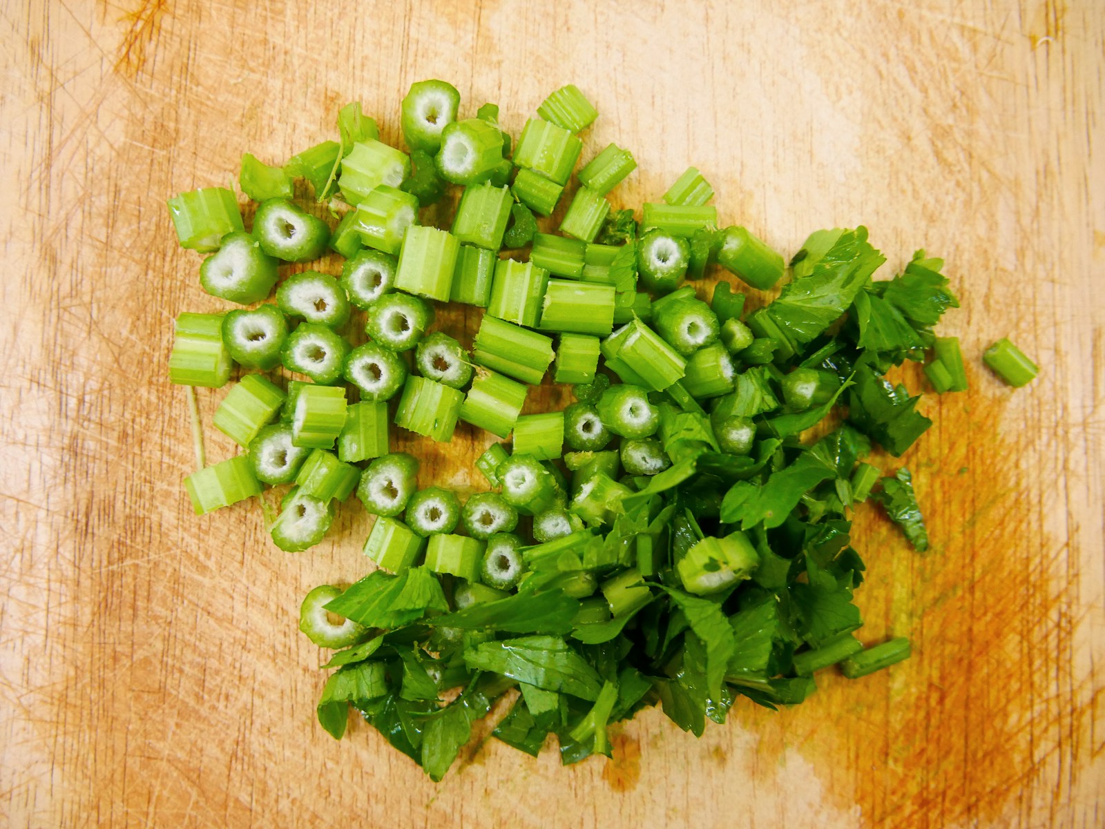Chopped celery stalks and leaves on a wooden cutting board