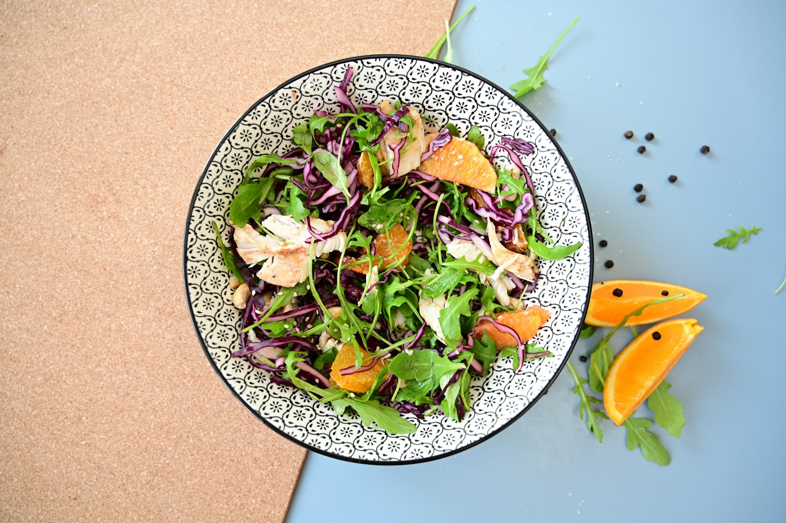Bowl of rocket, red cabbage, chicken and orange salad