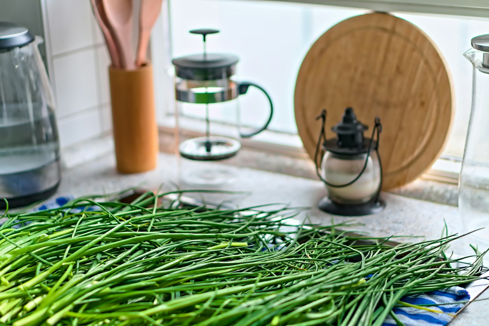 A large pile of freshly cut chive leaves on a kitchen counter