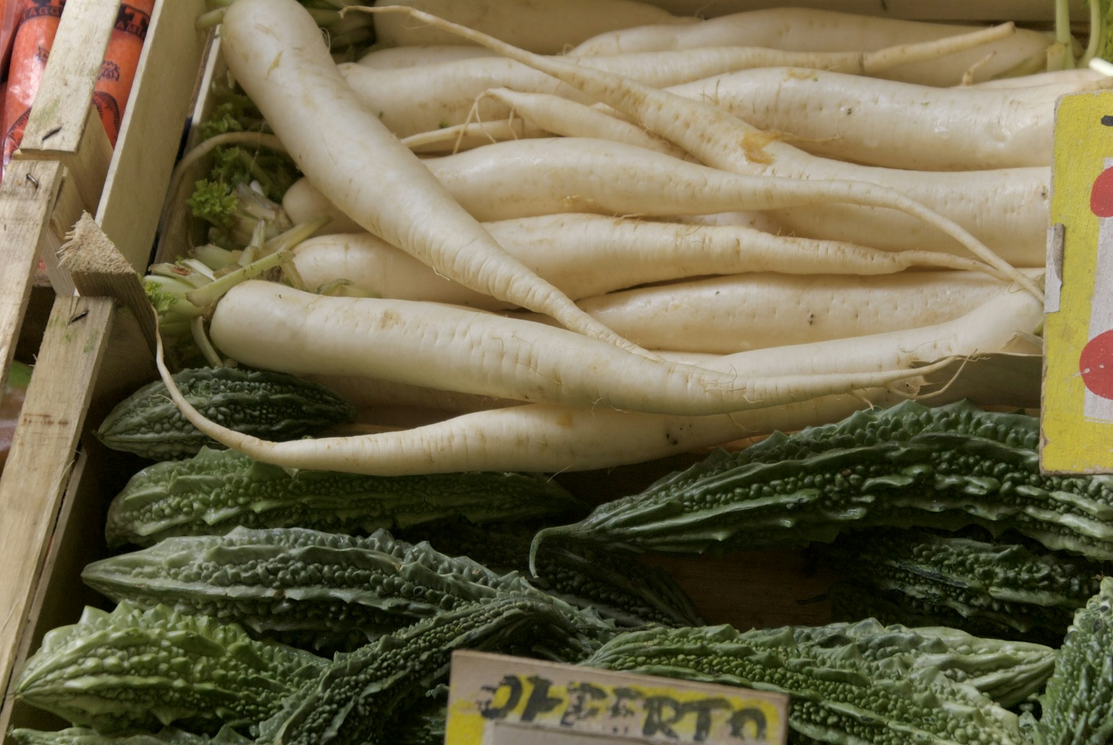 Long white daikon-type radishes in a wooden market crate